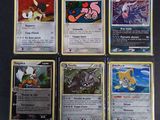 Plusieurs cartes Pokémon sont disposées sur une surface noire