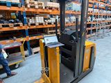 a man that is sitting on a forklift in a warehouse