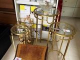three tables and a chair in a store with a vase of flowers on the table