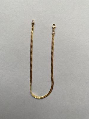 la chaîne en or est fixée au fermoir du collier