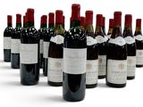 bottles of red wine lined up in a row on a white surface