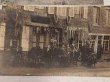 a old photo of a group of people standing outside of a building