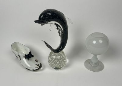 une figurine de dauphin à côté d'une paire de chaussures et d'un verre à vin