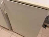 a microwave sitting on top of a small white refrigerator