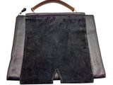 black and brown leather handbag with a wooden handle on a white background