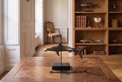 une sculpture représentant un requin posée sur une table dans un salon