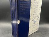 a set of three books with signatures on them sitting on a table