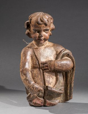 une vieille statue en bois représentant un enfant tenant un bâton