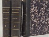 trois vieux livres posés l'un sur l'autre sur une surface blanche