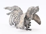 a silver figurine of a rooster on a white background