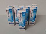 quatre tubes de dentifrice posés sur une table