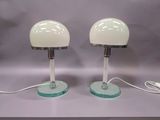 une paire de lampes de table en verre blanc avec des pieds transparents et un cordon blanc