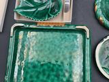 a green tray with a statue on it next to other dishes