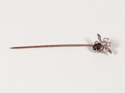 un petit bâtonnet en argent orné d'une fleur rouge