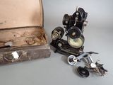 a suitcase and an old type of sewing machine next to each other