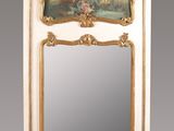 an ornately decorated mirror with a painting hanging on the wall