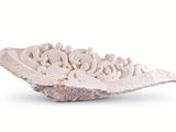 a white sculpture of a leaf with a group of people on it