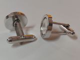 pair of silver cufflinks on white surface with white background