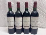 four bottles of wine are lined up on a table