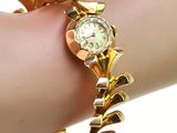 une femme portant un bracelet en or avec une montre au poignet