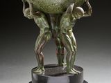 sculpture en bronze représentant deux hommes tenant un bol sur un socle
