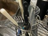 many kitchen utensils in a wire basket on the counter