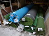 plusieurs rouleaux de moquette verte et bleue posés à même le sol