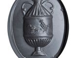 a metal plaque with a vase on it on a white background