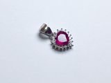 une photo d'un pendentif orné d'un diamant rose et blanc, posé sur une surface blanche