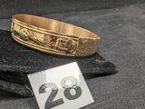 un bracelet en or portant un numéro, posé sur un tissu noir