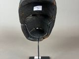 a close up of a helmet on a stand on a white surface
