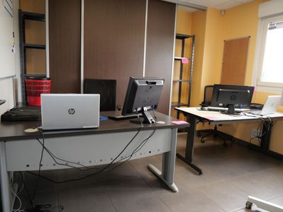 a desk with two computers and a laptop on it