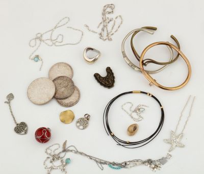 de nombreux colliers et bracelets de toutes sortes disposés sur une surface blanche