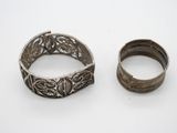 deux bracelets en argent et une bague en argent posés sur une surface blanche