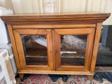 a wooden cabinet with two glass doors on it