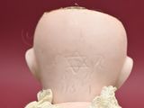 a small doll with a white dress on it ' s back