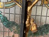 a statue of jesus on a cross in front of a stained glass window