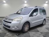 la camionnette argentée est garée sur un sol en damier dans le garage