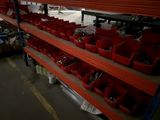 many red bins on the shelves in the warehouse