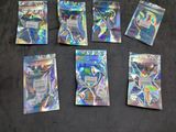 six packs of pokemon trading cards on a black surface