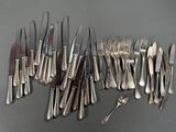 many forks and spoons laid out on the table