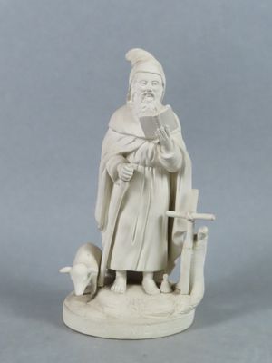 une statue représentant un homme assis sur une chaise en train de lire un livre