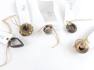 five bells with tags attached to them on a white surface