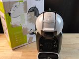 a coffee maker sitting on a table next to a box