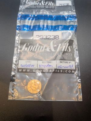 un sac de pièces posé sur une table à côté d'une paire de ciseaux