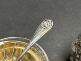 a silver spoon sitting next to a glass of liquid