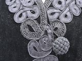 an image of a close up of a black dress with white lace on it