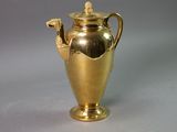 a gold vase that is sitting on a table