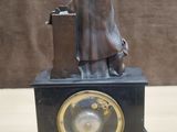 a bronze statue of a man with a suitcase on a table