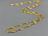 a close up of a gold necklace on a gray surface